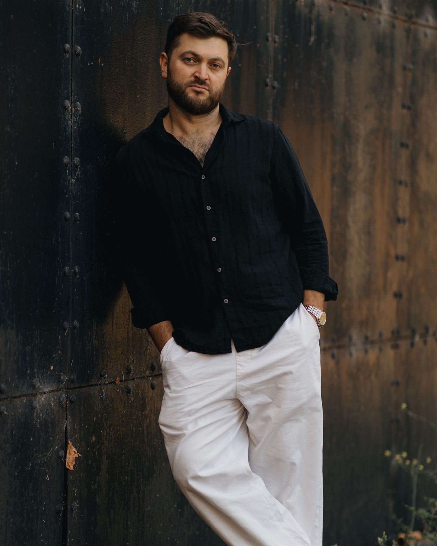 Portrait of a man leaning on a metal wall