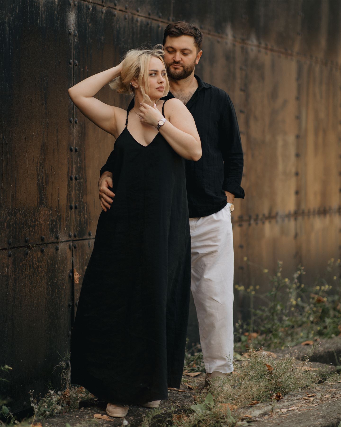 Couple in front of a rusted wall