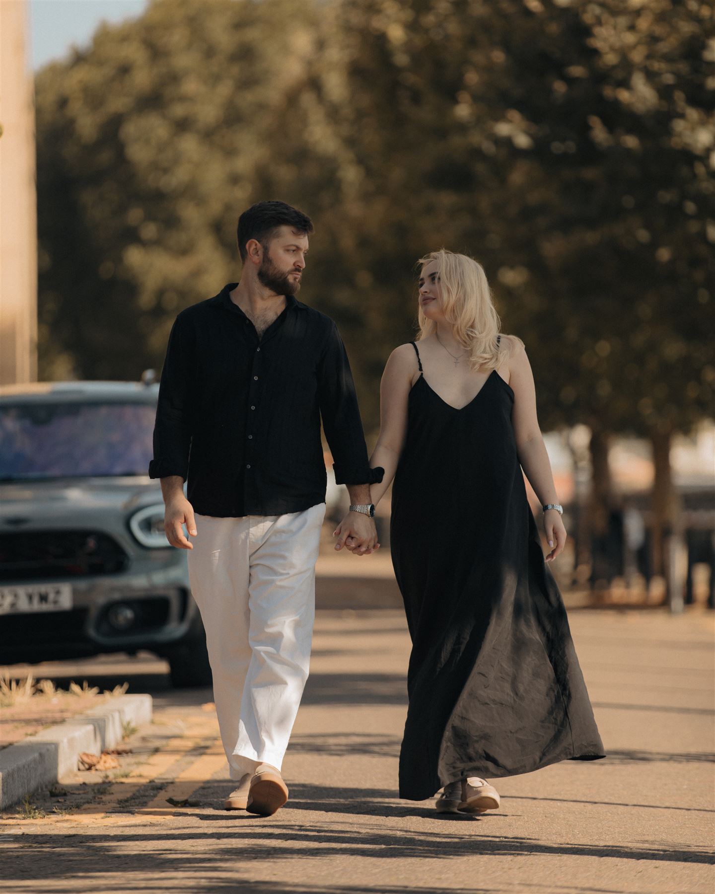 Couple walking down a tree-lined street