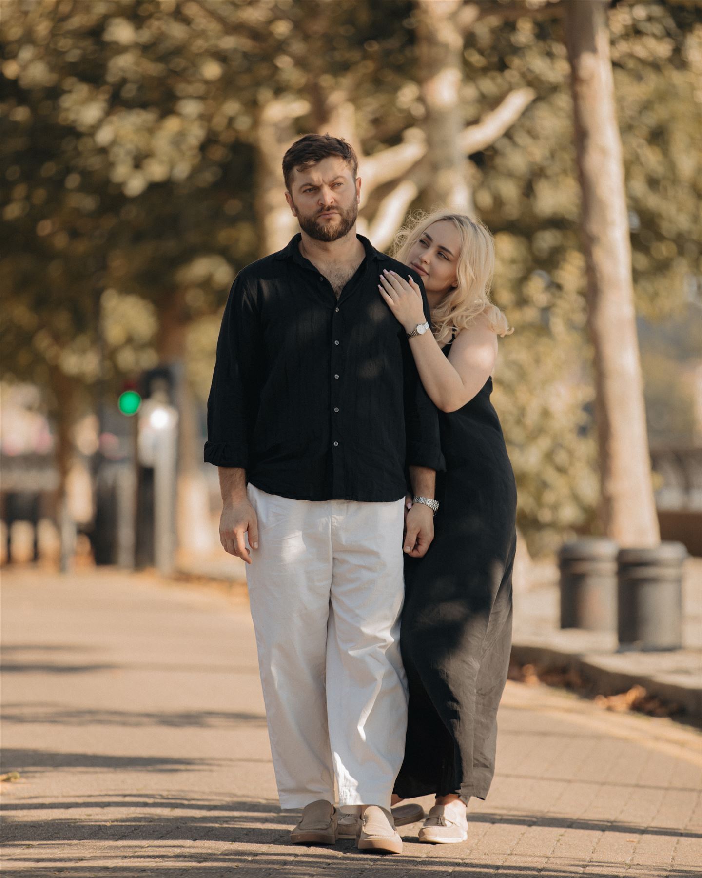 She holds his arm on the street