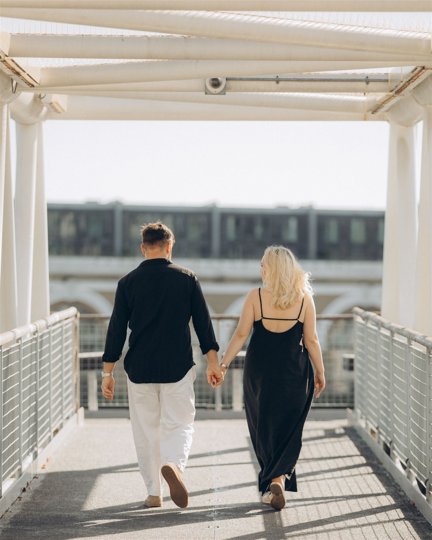 Holding hands on a white footbridge