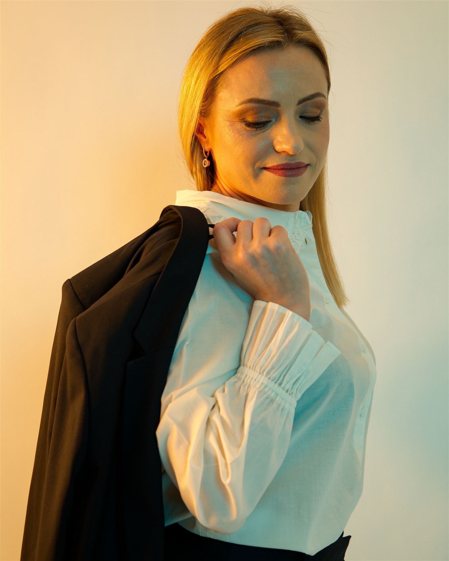 Aliona with her jacket over her shoulder in warm light